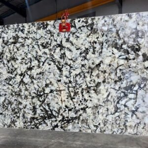 White granite slab with black veining pattern in stone warehouse display ALASKA WHITE