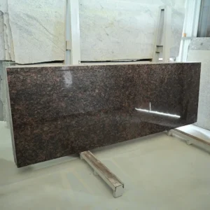 Tan Red Granite slab with natural red and black mineral pattern at GL Stone Expo