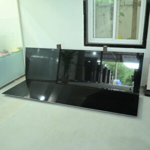 Premium polished Black Granite slab displayed in a granite showroom with a mirror finish.