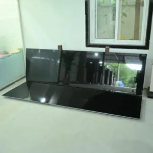 Premium polished Black Granite slab displayed in a granite showroom with a mirror finish.