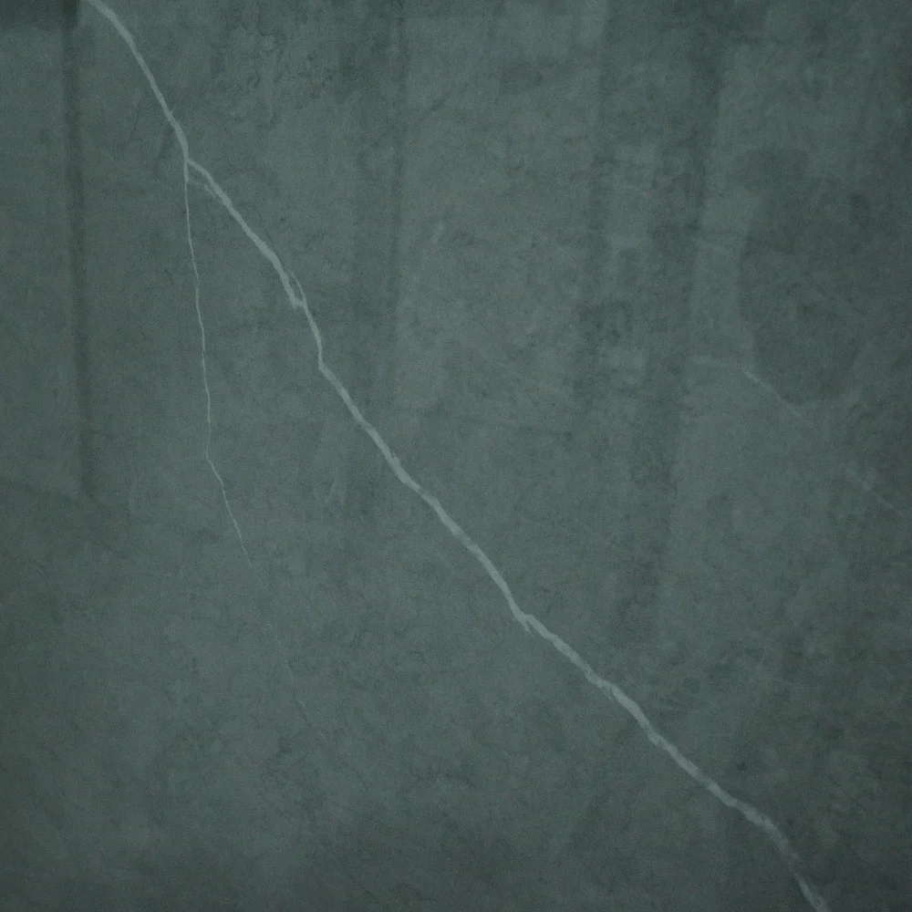 Pietra Grigeo Max Tile featuring a dark grey-green surface with elegant white veining