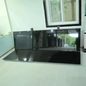 Premium Black Granite slab with a glossy polished surface displayed in a natural stone showroom.
