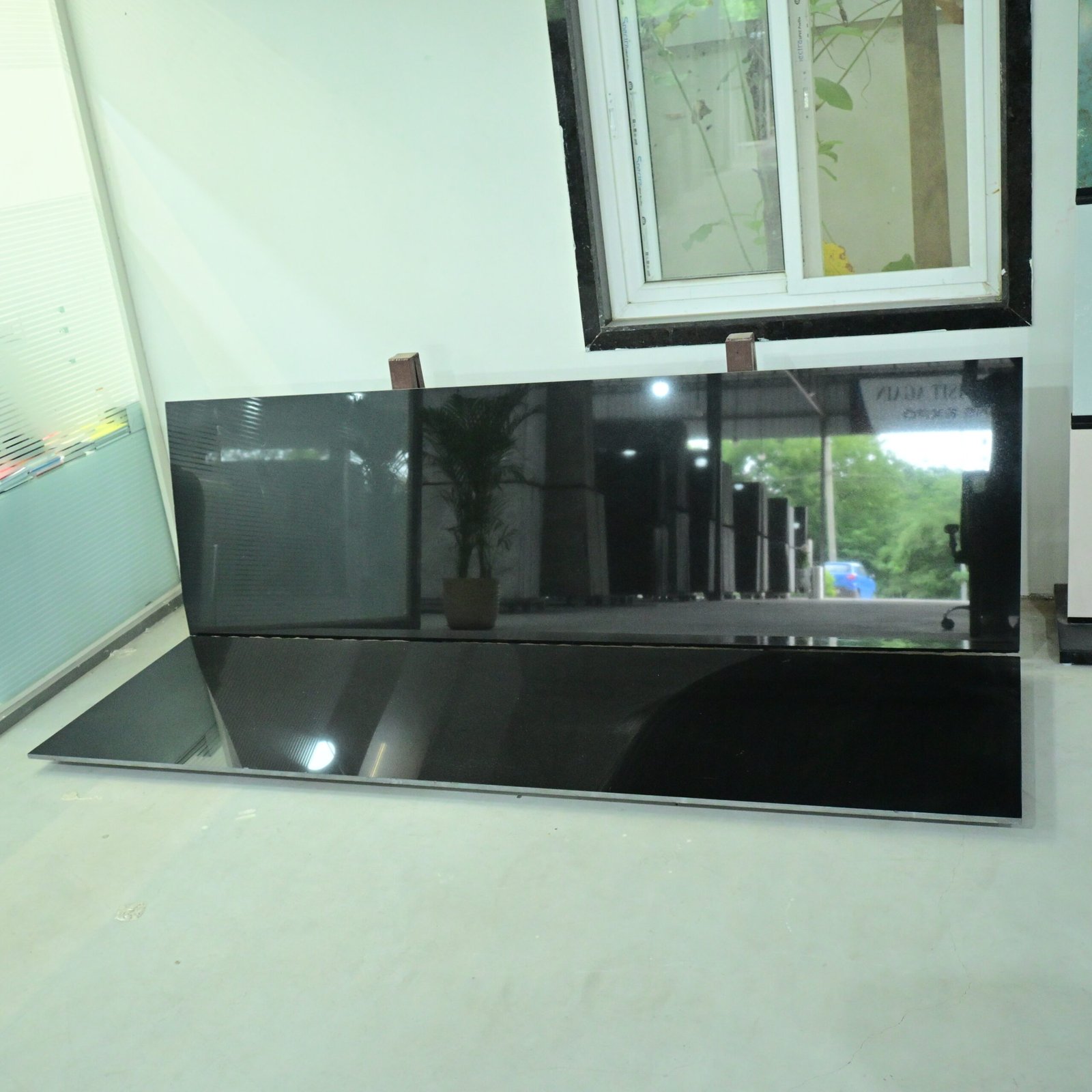 Premium Black Granite slab with a glossy polished surface displayed in a natural stone showroom.