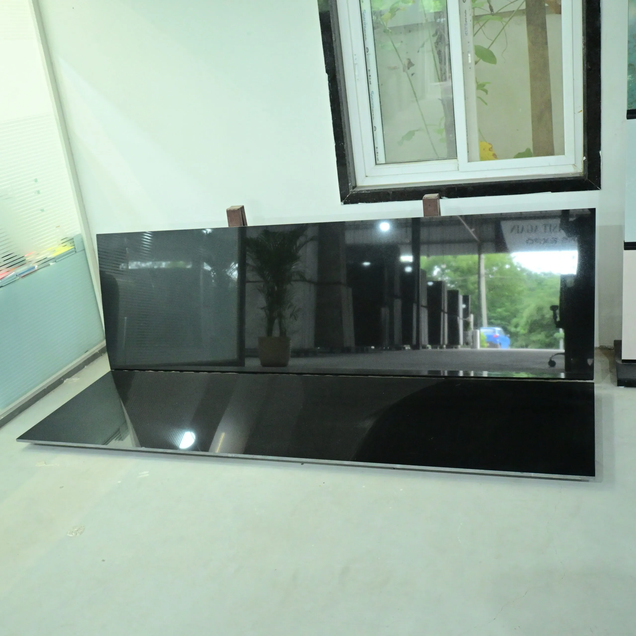 Premium Black Granite slab with a glossy polished surface displayed in a natural stone showroom.